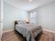 This bedroom boasts a window with white blinds and curtains, and wood laminate flooring at 3205 Royal Tern Dr, Winter Haven, FL 33881