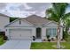Charming single-story home with a two-car garage, lovely landscaping, and a welcoming front entrance with beautiful flowers at 3205 Royal Tern Dr, Winter Haven, FL 33881