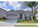 Charming single-story home with a two-car garage, lovely landscaping, and a welcoming front entrance with beautiful flowers at 3205 Royal Tern Dr, Winter Haven, FL 33881
