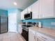 Updated kitchen with stainless steel oven and cooktop with white cabinets and access to backyard at 3205 Royal Tern Dr, Winter Haven, FL 33881