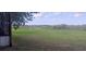 Lush green backyard view with a tranquil pond, partially framed by trees at 9873 County Road 114B, Wildwood, FL 34785