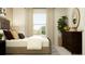 Bright bedroom featuring a stylish bed frame, neutral walls, view of the yard, and a live plant at 2751 Pioneer Trl, Eagle Lake, FL 33839