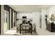 Open dining area with a dark wooden table, white chairs, and modern white kitchen in the background at 2751 Pioneer Trl, Eagle Lake, FL 33839