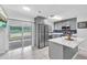 Modern kitchen features gray cabinets, stainless steel appliances, and a breakfast bar with granite countertops at 3360 Cross Fox Dr, Mulberry, FL 33860