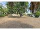 Spacious backyard with mature trees providing shade and a distant view of the house at 1895 Emerson Ave, Bartow, FL 33830