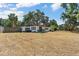 Expansive backyard featuring lush trees and a charming single-story home with an inviting outdoor seating area at 1895 Emerson Ave, Bartow, FL 33830