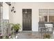Covered front porch with decor, seating and a black front door with glass insert at 1895 Emerson Ave, Bartow, FL 33830