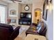 Spacious living room with tile floors, fireplace, and comfortable dark brown leather seating at 242 Prestwick Dr, Davenport, FL 33897