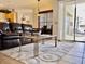 Comfortable living room with dark brown leather furniture and access to outdoor patio at 242 Prestwick Dr, Davenport, FL 33897
