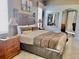 Comfortable primary bedroom with detailed headboard, tiled floors, and elegant decor with a view of the living room at 242 Prestwick Dr, Davenport, FL 33897