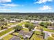 An aerial view showing a white single-Gathering home with a fenced yard and mature trees in a suburban neighborhood at 424 Forest Glen Ave, Lakeland, FL 33813