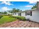 Back exterior showing a patio, lush landscaping, and charming brick accents at 424 Forest Glen Ave, Lakeland, FL 33813
