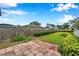 Backyard featuring a well-maintained lawn with border hedges and a brick paver area at 424 Forest Glen Ave, Lakeland, FL 33813