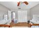 Bedroom with two beds, ceiling fan, and white closet doors; featuring two vanity tables with mirrors at 424 Forest Glen Ave, Lakeland, FL 33813