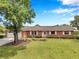 Well-maintained brick home showcasing lush lawn and mature trees in a serene setting at 424 Forest Glen Ave, Lakeland, FL 33813