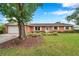 Inviting brick home with a lush green lawn and tidy landscaping enhances its curb appeal at 424 Forest Glen Ave, Lakeland, FL 33813
