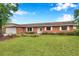 Charming brick home featuring a well-manicured lawn and bright white trim around the windows at 424 Forest Glen Ave, Lakeland, FL 33813