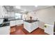 Well-lit kitchen featuring an island, white cabinets, and hardwood flooring at 424 Forest Glen Ave, Lakeland, FL 33813