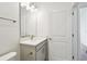 This bright bathroom has a modern vanity with a light gray cabinet and an oval mirror at 5914 Bristle Oak St, Mount Dora, FL 32757