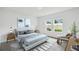 Comfortable bedroom with soft natural light, a cozy chair and two windows overlooking the backyard at 5914 Bristle Oak St, Mount Dora, FL 32757
