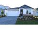 Charming single-Gathering home featuring a well-manicured lawn and a paved driveway leading to an attached two-car garage at 5914 Bristle Oak St, Mount Dora, FL 32757