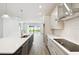 Modern kitchen featuring stainless steel appliances, a large island, and a view of the backyard through sliding glass doors at 5914 Bristle Oak St, Mount Dora, FL 32757