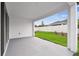 A covered patio with a view of the lawn, fence, and neighboring home at 5914 Bristle Oak St, Mount Dora, FL 32757