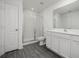 Clean bathroom with a glass-enclosed shower, white cabinets, and wood-look flooring at 113 Cimarron Ln, Poinciana, FL 34759