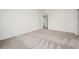 Empty bedroom showing the plush carpet, and view of the hallway at 113 Cimarron Ln, Poinciana, FL 34759