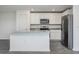 Modern kitchen featuring white cabinets, stainless steel appliances, and granite countertops at 113 Cimarron Ln, Poinciana, FL 34759