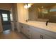 Bright bathroom featuring double vanity, quartz countertop, and a large framed mirror at 6051 Sacred Oak Ave, Mount Dora, FL 32757