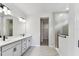 Bathroom featuring double sinks, a large mirror, and a glass-enclosed shower at 6051 Sacred Oak Ave, Mount Dora, FL 32757