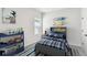 Youthful bedroom with surfboard decor, a blue plaid bedspread, and playful accents at 6051 Sacred Oak Ave, Mount Dora, FL 32757