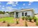 Back exterior view showcasing the covered patio, landscaping, and fenced yard, ideal for outdoor activities at 6051 Sacred Oak Ave, Mount Dora, FL 32757
