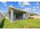 Rear exterior view highlighting the covered patio, manicured lawn, and privacy fence, great for entertaining at 6051 Sacred Oak Ave, Mount Dora, FL 32757