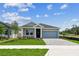 Charming single Gathering home with manicured lawn and paved driveway under a sunny sky at 6051 Sacred Oak Ave, Mount Dora, FL 32757