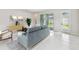 Bright living room with tile floors, modern furniture, and sliding glass doors to the backyard at 6051 Sacred Oak Ave, Mount Dora, FL 32757