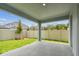 Covered patio overlooking the fenced backyard with lush grass and a young tree, ideal for outdoor living at 6051 Sacred Oak Ave, Mount Dora, FL 32757