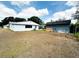 A quaint, white house with a well-sized backyard and a shed, set under a sky with scattered clouds at 1690 S Mcadoo Ave, Bartow, FL 33830