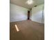 Bedroom featuring neutral carpet, with a closet, an opening to the bathroom, and a view to hardwood flooring beyond at 1690 S Mcadoo Ave, Bartow, FL 33830
