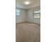 Bedroom featuring neutral carpet, natural lighting from two windows, and a clean aesthetic at 1690 S Mcadoo Ave, Bartow, FL 33830