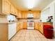 Functional kitchen with wooden cabinets, tile flooring, and essential appliances at 1690 S Mcadoo Ave, Bartow, FL 33830