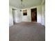 Spacious living room with neutral carpet flooring and an open doorway to another room at 1690 S Mcadoo Ave, Bartow, FL 33830