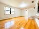Open-concept living room features wood floors, a window view, and flows into the dining and kitchen areas at 1690 S Mcadoo Ave, Bartow, FL 33830