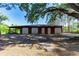 Wide barn with multiple bays, situated on a grassy lot, with trees and shaded parking at 1836 Cr 609B, Bushnell, FL 33513