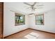 Bright bedroom featuring laminate flooring, ceiling fan, and windows with wooded views at 1836 Cr 609B, Bushnell, FL 33513
