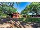 Quaint red home featuring a covered porch and surrounded by mature trees in a spacious yard at 1836 Cr 609B, Bushnell, FL 33513