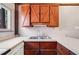 Vintage kitchen with wood cabinets, white countertops, and stainless steel sink at 1836 Cr 609B, Bushnell, FL 33513