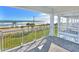 Covered balcony with a beach and ocean view, decorated with white railings, columns and brick flooring at 23 Marden Dr # 51, Ormond Beach, FL 32176