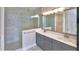 Bathroom with double sink vanity, tiled glass shower, light gray cabinets and white walls at 23 Marden Dr # 51, Ormond Beach, FL 32176